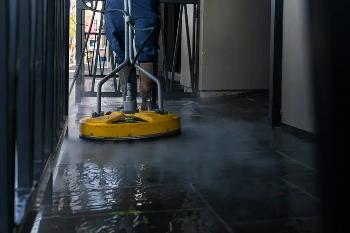 Surface cleaner pressure washing a wet paved floor