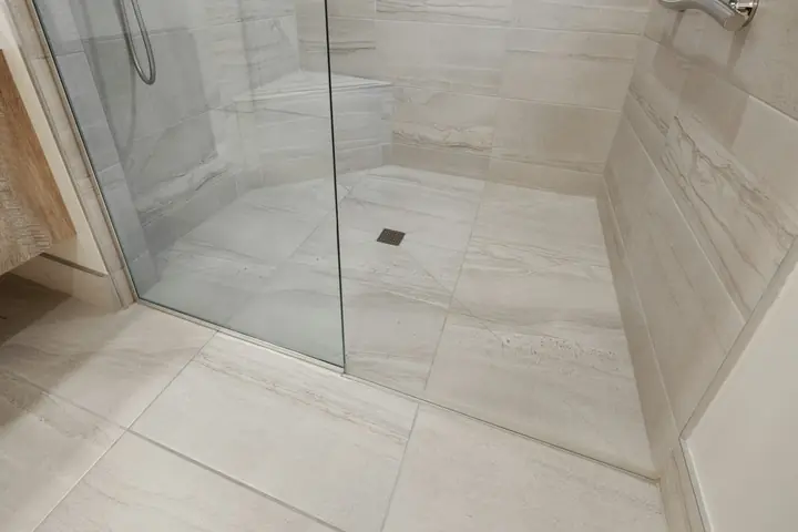 Clean shower with glass screen and light floor tiles